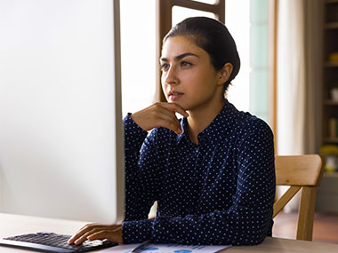 Young woman studying information on computer