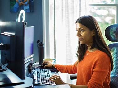 Woman at home office while working at her desk on a computer.