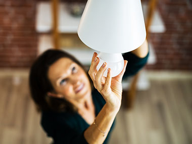 Woman screwing in light bulb
