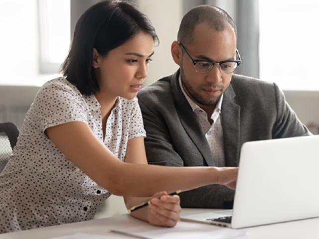 A mixed couple examine information on a laptop