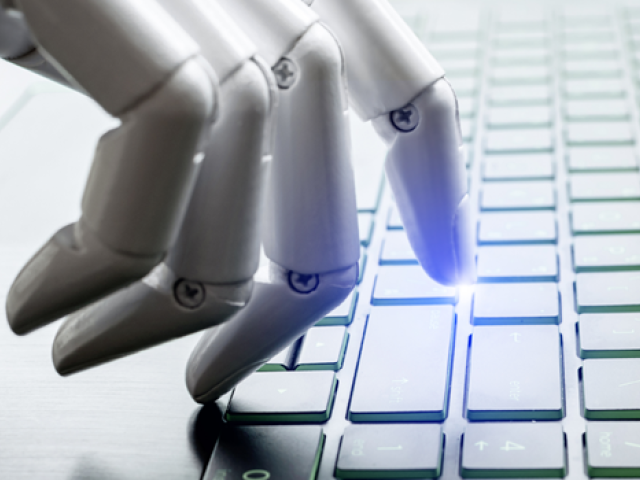 Close-up of a robotic hand using a keyboard