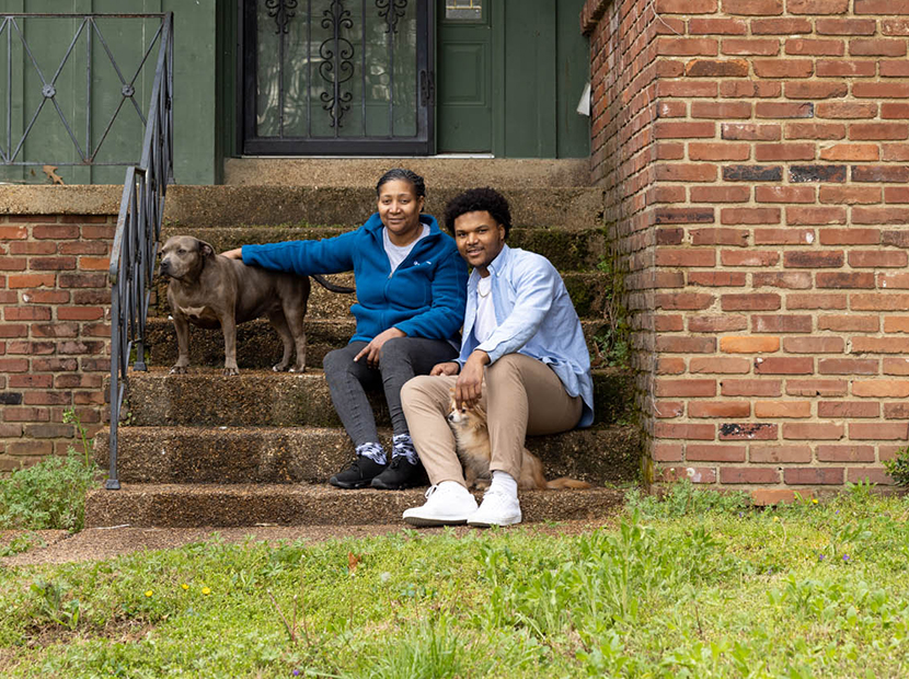 Family with 2 dogs sitting on their front steps