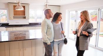 realtor talking to a couple in a kitchen